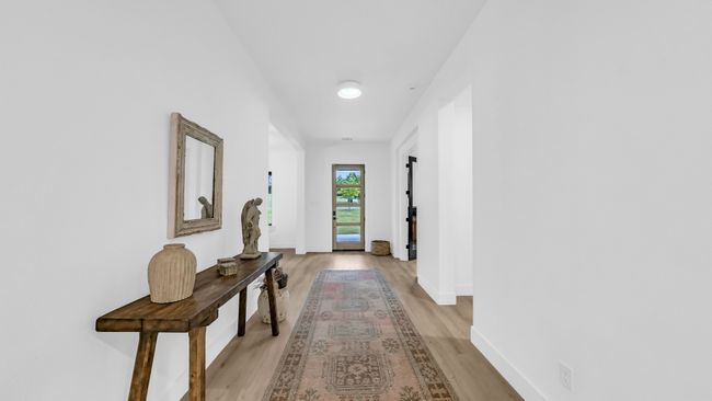 Hallway with light wood-type flooring and baseboards | Image 4