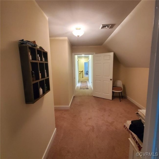 Hallway featuring visible vents, baseboards, carpet, and vaulted ceiling | Image 42