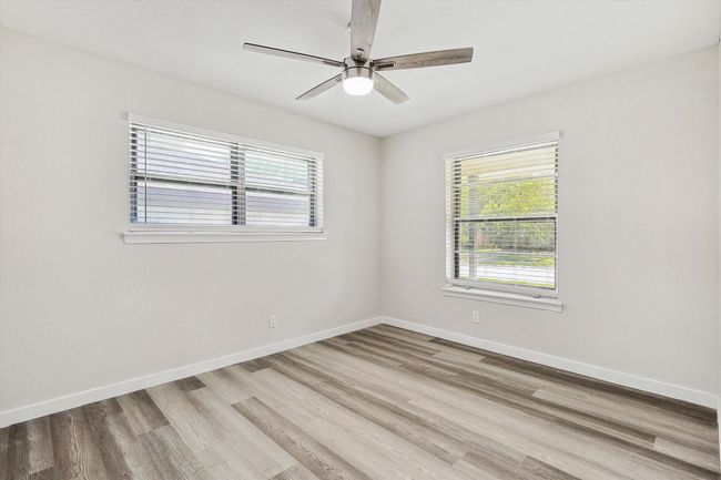 Spare room with a wealth of natural light, wood finished floors, and a ceiling fan | Image 29