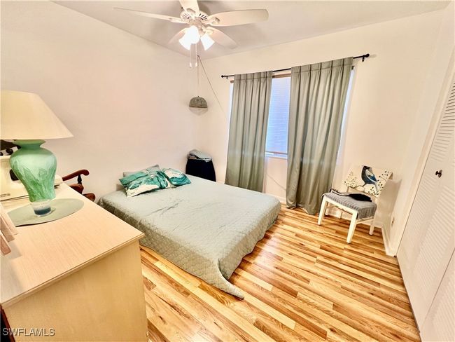Bedroom featuring light wood-style floors and ceiling fan | Image 15