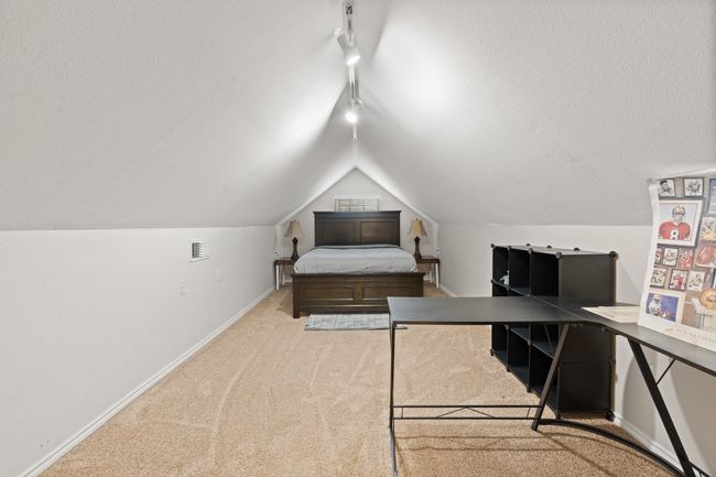 Bedroom featuring rail lighting, carpet flooring, and lofted ceiling | Image 19