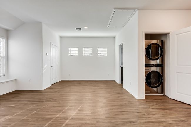 Garage apartment with stacked washer and clothes dryer, attic access, plenty of natural light, and light wood-style floors | Image 35