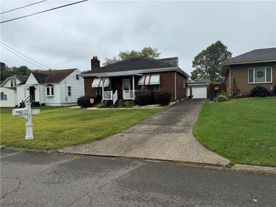 View of front of home with a garage, a front lawn, and covered porch | Image 2