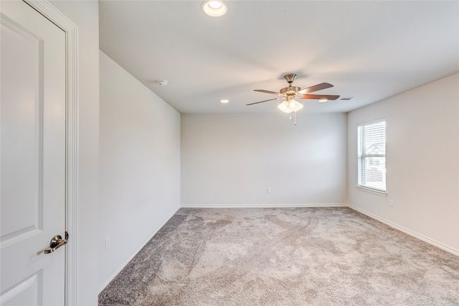 Carpeted empty room with a ceiling fan, recessed lighting, baseboards, and a smoke detector | Image 23