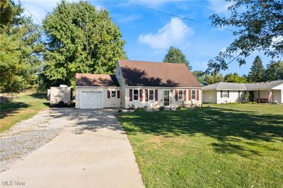 New england style home with a front lawn and a garage | Image 2