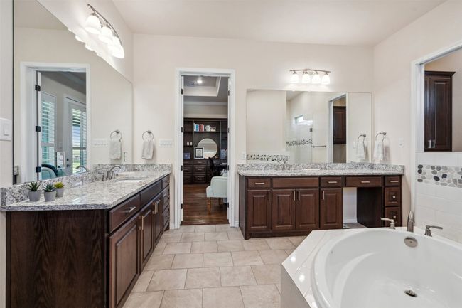 Full bathroom featuring two vanities, a garden tub, a sink, and tiled shower | Image 29