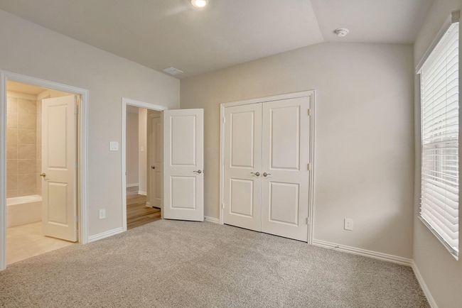 Unfurnished bedroom featuring light carpet, a closet, and connected bathroom | Image 18