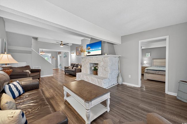 Living room featuring wood finished floors, a ceiling fan, and a fireplace | Image 16