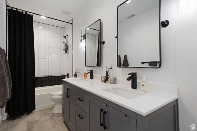 Bathroom with shower / bath combo, toilet, a sink, and visible vents | Image 29