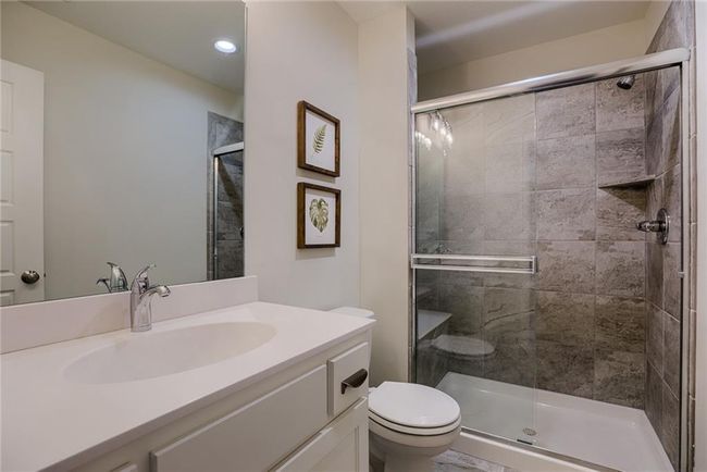 Bathroom featuring vanity with extensive cabinet space, an enclosed shower, and toilet | Image 45