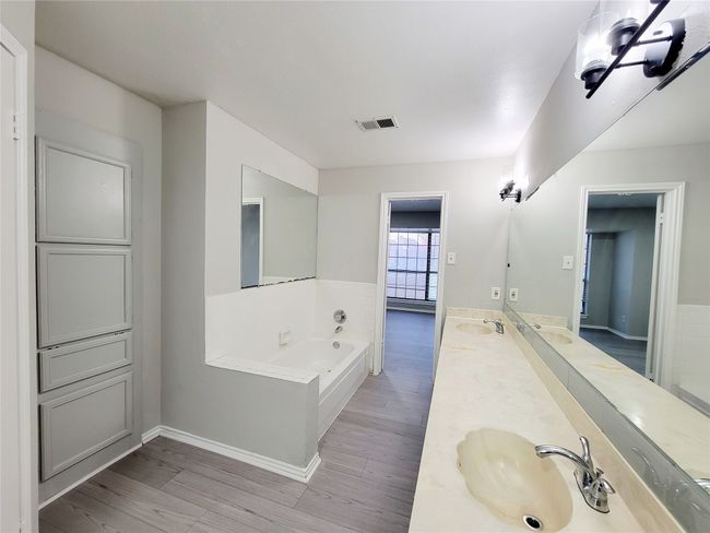 Bathroom with hardwood / wood-style floors, vanity, and tiled tub | Image 13