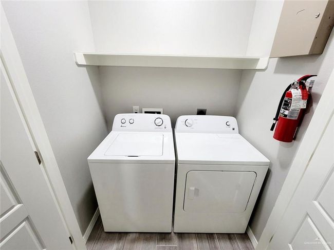 Laundry room with washer and dryer and light wood-style flooring | Image 17