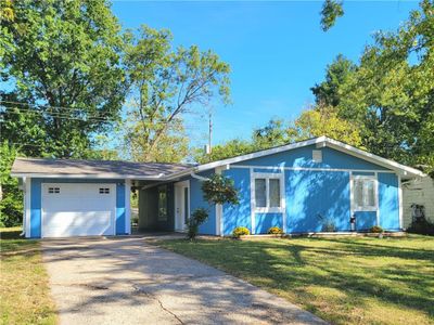 Ranch-style home featuring a garage and a front lawn | Image 1