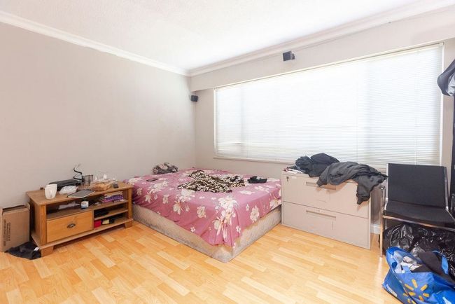 Bedroom with wood finished floors and crown molding | Image 25