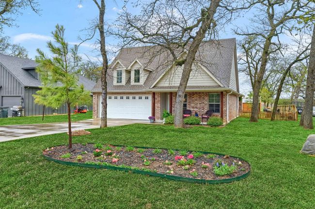 View of front of property featuring fence, concrete driveway, a front yard, brick siding, and a shingled roof | Image 5