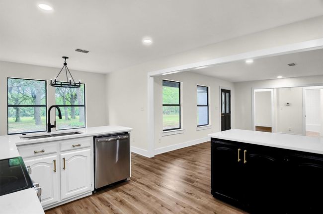 Kitchen with stainless steel dishwasher, light countertops, a sink, healthy amount of natural light, and recessed lighting | Image 10