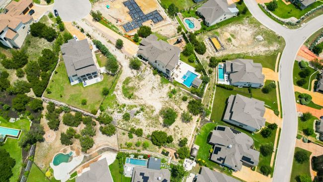 Aerial overview of property's location with a pool area and nearby suburban area | Image 12