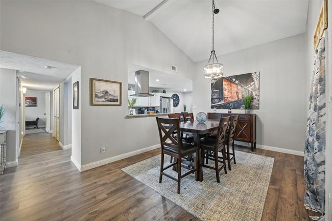 Dining room with a chandelier, wood finished floors, and high vaulted ceiling | Image 10