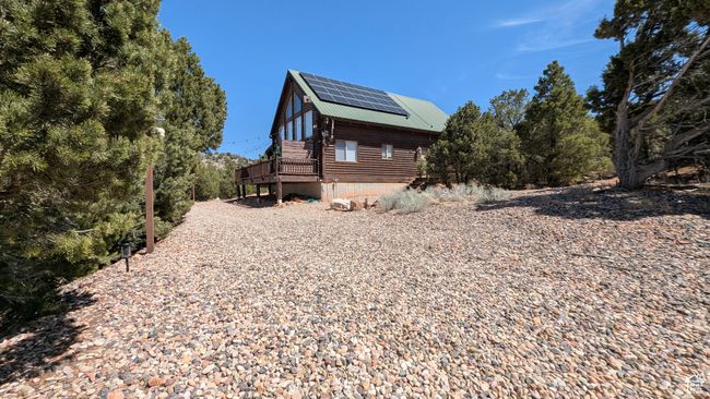 View of side of property featuring metal roof, a wooden deck, and solar panels | Image 22