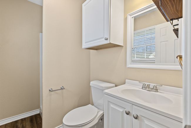 Primary bathroom featuring baseboards, vanity, toilet, shower and wood finished floors | Image 21