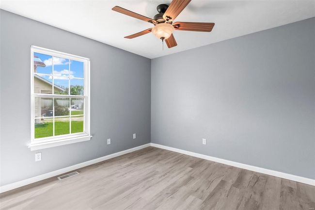 Unfurnished bedroom with a closet, wood finished floors, and baseboards | Image 16