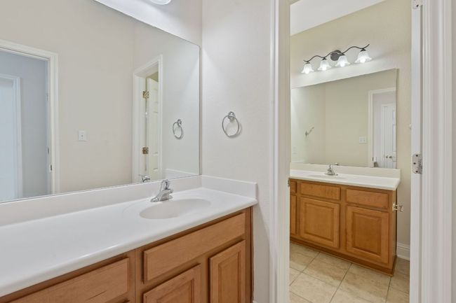 Bathroom with a sink, tile patterned flooring, and two vanities | Image 29