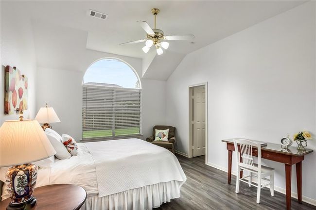 Primary bedroom features a beautiful arched window. | Image 21