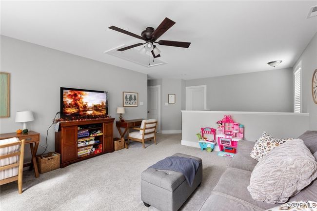 Carpeted living room featuring ceiling fan and visible vents | Image 26