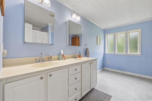 Full bathroom featuring a stall shower, crown molding, tile patterned flooring, and a textured ceiling | Image 21