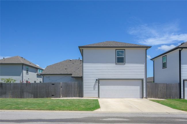 Traditional home featuring driveway, an attached garage, and a shingled roof | Image 26