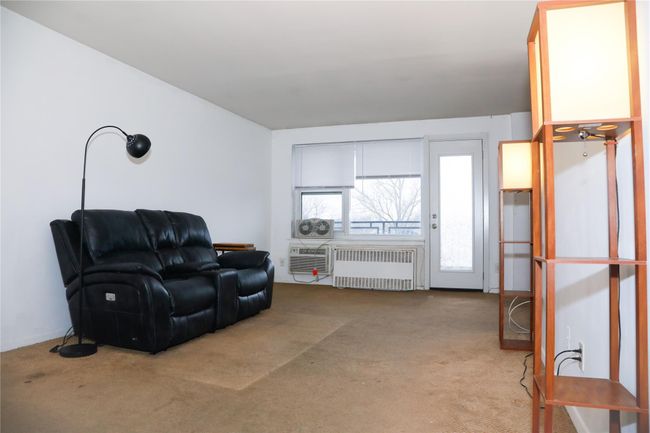 Living area featuring radiator and carpet flooring | Image 4