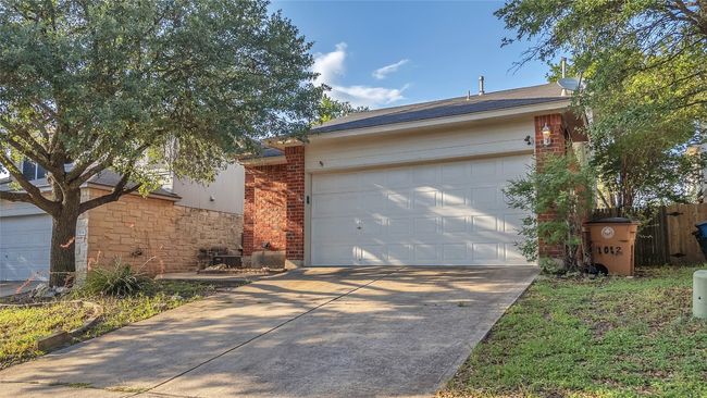 View of front facade featuring concrete driveway, stone siding, an attached garage, and brick siding | Image 30