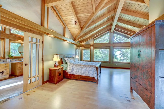 Primary suite with wall of windows looking out to the lake | Image 36