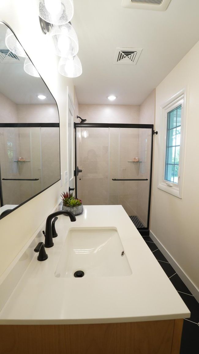 The upstairs hall bath is newly remodeled and spotlights an eye-catching geometric shower tile, a new wood vanity, quartz countertops and brand new lighting. | Image 20