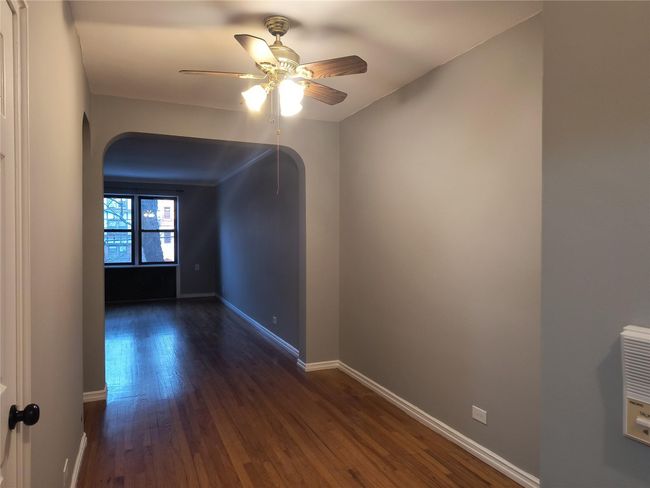 Unfurnished room featuring arched walkways, dark wood-style floors, baseboards, and a ceiling fan | Image 13