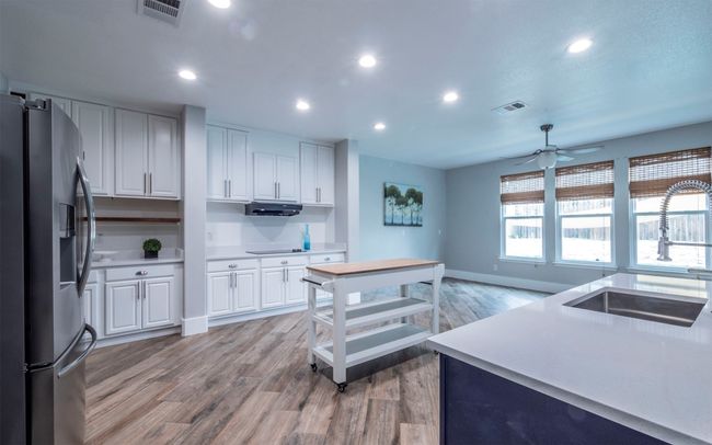 Open kitchen, family room and breakfast room with beautiful wood tile floors and space to move around! Natural light galore! | Image 5