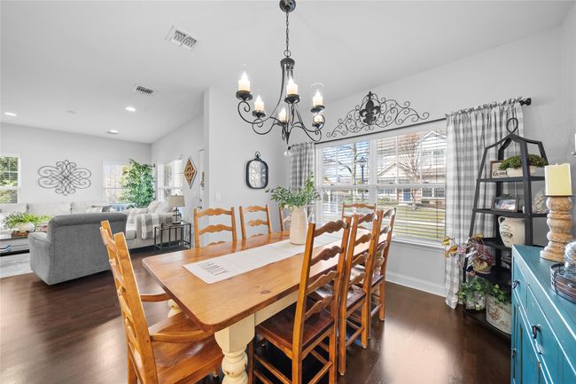 Dining space featuring dark wood finished floors, visible vents, and a chandelier | Image 10