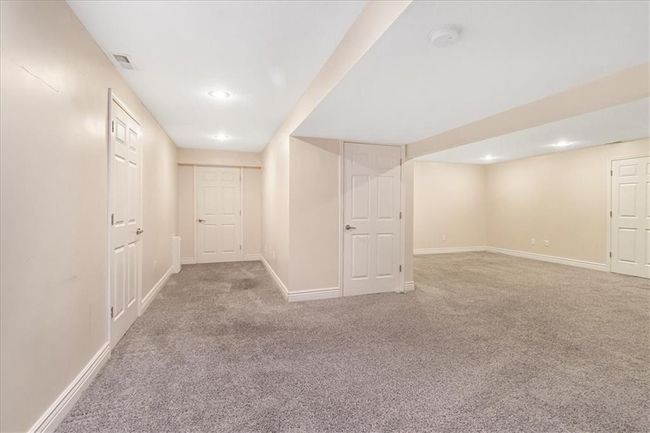 Finished basement with carpet flooring, recessed lighting, baseboards, and visible vents | Image 40