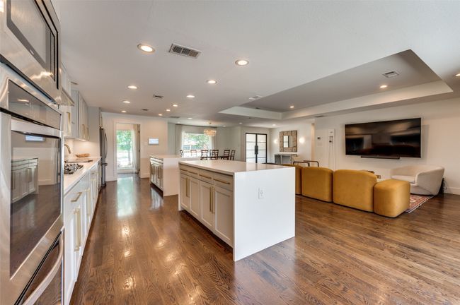 Kitchen with appliances with stainless steel finishes, open floor plan, dark wood-style flooring, and recessed lighting | Image 13