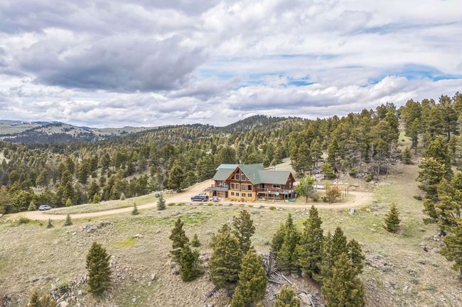 Aerial view of property and surrounding area with a forest and a mountain backdrop | Image 12