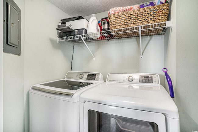 Washroom with electric panel, washing machine and clothes dryer, and a textured ceiling | Image 26
