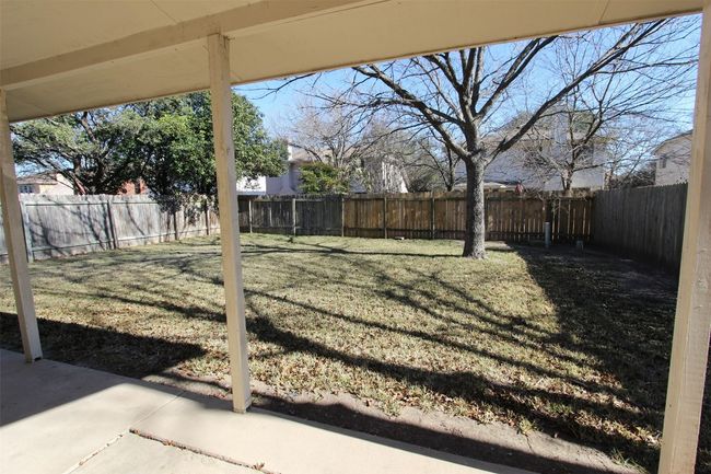 Fenced backyard with a patio | Image 23