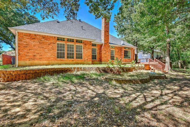 Back of house featuring brick siding, a shingled roof, and a chimney | Image 34