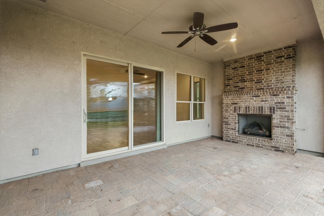 View of patio featuring an outdoor brick fireplace and ceiling fan | Image 28