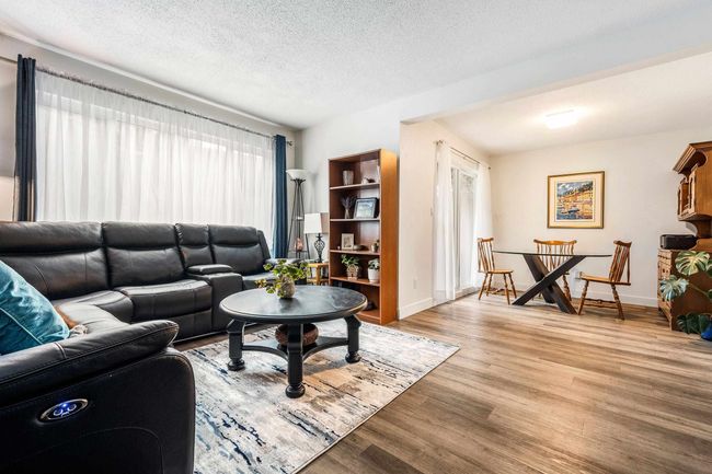 Living room featuring a textured ceiling, light wood-type flooring, and baseboards | Image 10