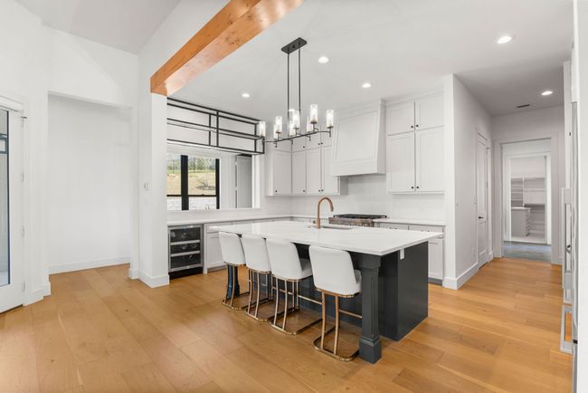 Kitchen featuring light countertops, a sink, light wood-style flooring, and wall chimney exhaust hood | Image 9