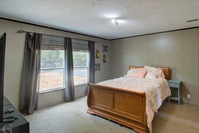 Bedroom with light colored carpet and a textured ceiling | Image 11