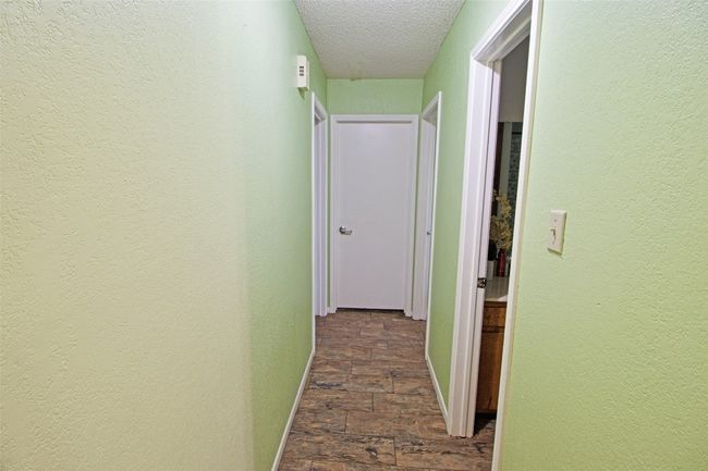 Hallway with baseboards, a textured wall, and a textured ceiling | Image 13