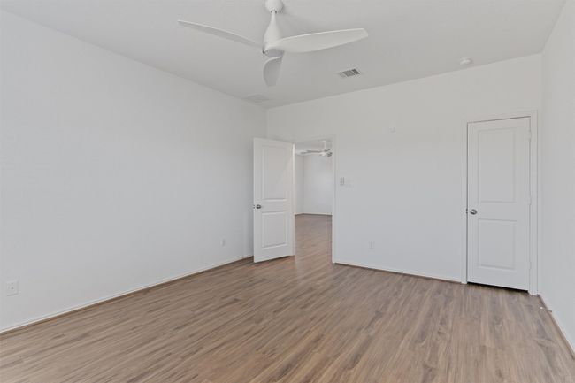 Unfurnished room featuring light wood-style flooring, visible vents, and ceiling fan | Image 13
