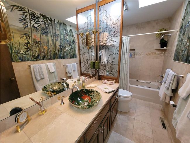 Full bath with tile patterned flooring, vanity, toilet, visible vents, and shower / bath combo with shower curtain | Image 49
